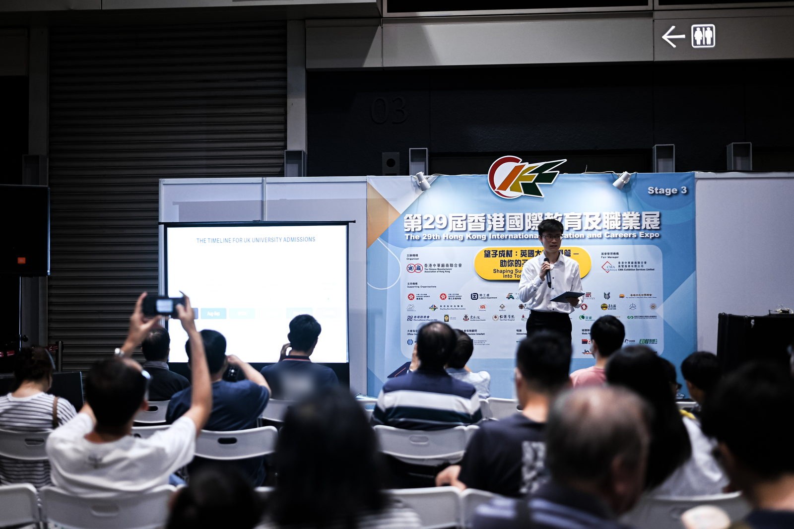 Presenting the UK admissions timeline from the expo stage to a seated audience of Hong Kong parents.